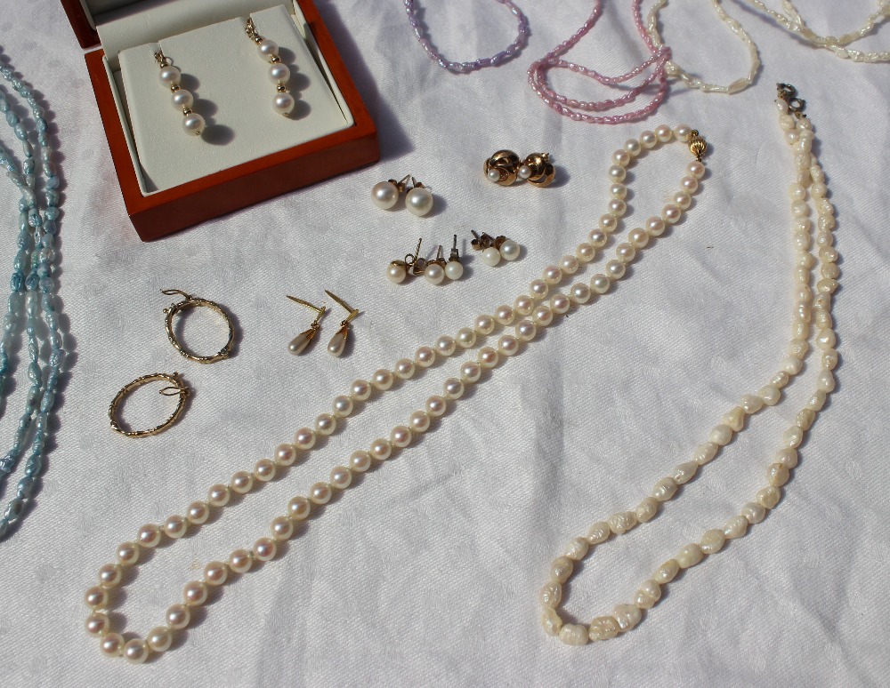 A pearl necklace together with pearl drop earrings, other earrings,