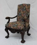 A 19th century mahogany library chair with a pad upholstered back and seat with scrolling leaf