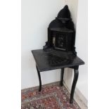 A 19th century Low Countries ebonised corner cabinet / table, with a gladiator carved door,