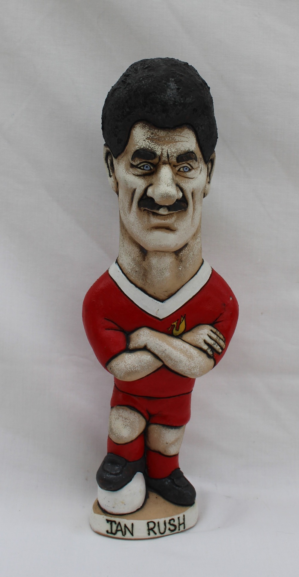 A John Hughes pottery Grogg of Ian Rush, with arms folded and foot raised on a football,