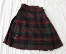 A kilt in a green red and yellow tartan