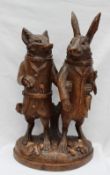 A 19th century Black Forest carved treen figure group in the form of a standing fox with knife and