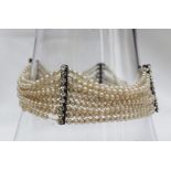 A nine strand pearl bracelet set with seed pearls to paste set bars,