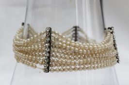 A nine strand pearl bracelet set with seed pearls to paste set bars,