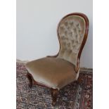 A Victorian mahogany framed nursing chair with a spoon shaped button upholstered back,