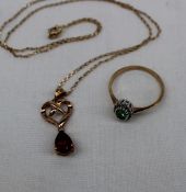 A 9ct yellow gold pendant set with a tear drop shaped garnet on a yellow metal chain,