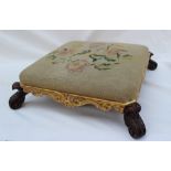A Victorian foot stool of square form, with a woolwork top, carved gilt edge and scrolling feet,