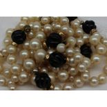 A three strand pearl and twisted bead necklace to a yellow metal clasp,