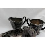 A Rockwell black glass and white metal overlay cream jug and matching twin handled sugar bowl,