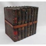 A Huntley and Palmer biscuit tin in the form of a row of books held together with a leather strap,