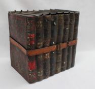 A Huntley and Palmer biscuit tin in the form of a row of books held together with a leather strap,