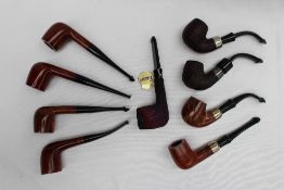 A collection of nine new, boxed Peterson pipes, one with a silver collar.