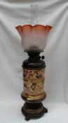 A Victorian pottery oil lamp, with a flared glass shade,