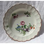 An 18th century English porcelain bowl, with a chocolate line edge and moulded border,