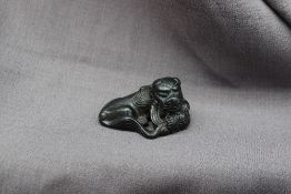 A bronze scroll weight in the form of a recumbent "lion dog" resting its head on a ball, 5.
