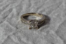 A diamond ring, set with four princess cut diamonds to a square setting, approximately 0.