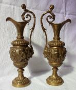 A pair of gilt bronze ewers cast with cherubs on a spreading foot,