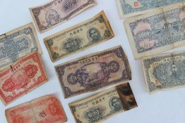A collection of Chinese bank notes, including five Yuan, One Hundred Yuan 1942,