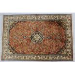 An Indian silk rug, with a burnt orange ground decorated with interlaced flowers,