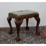 A George III and later walnut stool with an embroidered covered seat pad,