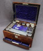 A Victorian walnut Lady's travelling box, of rectangular form inset with a mother of pearl shield,