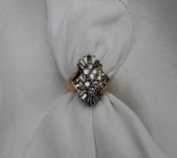 A diamond cluster ring set with nine round brilliants and baguette cut diamonds totalling