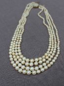 A four strand pearl necklace set with graduated pearls to a 9ct gold pearl set clasp,