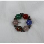 A hardstone brooch, of circular form set with moss agate, moonstones etc to a white metal setting,