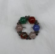 A hardstone brooch, of circular form set with moss agate, moonstones etc to a white metal setting,