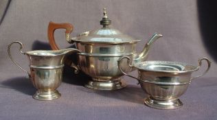 A George V silver three piece tea set, with a panelled body on a spreading foot, Birmingham, 1931,