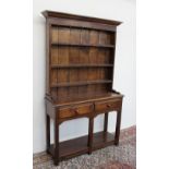 A 20th century oak dresser the moulded cornice above a rack with a planked back and three shelves,