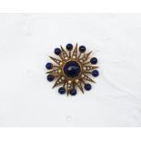 A lapis lazuli and seed pearl brooch of star form, set with a central cabochon lapis lazuli bead,