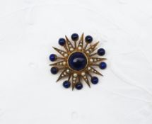 A lapis lazuli and seed pearl brooch of star form, set with a central cabochon lapis lazuli bead,