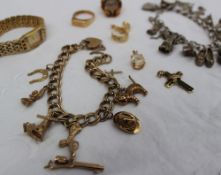 A 9ct gold charm bracelet, the charms include a cat, a hat, a pistol, a cross, a windmill,