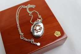A Clogau silver and 9ct yellow gold locket with a tree of life motif on a silver chain