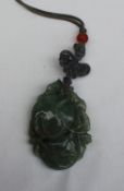 A carved jade pendant in the form of fruit and leaves on a cord necklace 55mm x 35mm