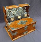 An oak tantalus, with silver plated mounts and a mirrored back, with three cut glass decanters,