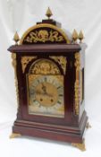 A gilt metal mounted mahogany bracket clock with a domed top and pineapple finials,