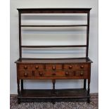 An 18th century South Wales oak dresser, the rack with a moulded cornice above two shelves,
