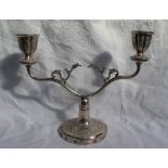 A white metal twin branch candelabra, decorated with flower heads and scrolls, 21.