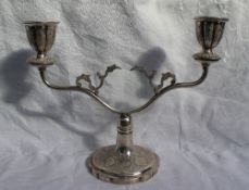 A white metal twin branch candelabra, decorated with flower heads and scrolls, 21.