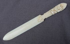 An ivory paper knife, the handle profusely carved with flower heads, fruit and leaves, 25.