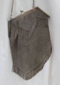 A white metal purse with a chain link and fringe design cast with flowers and leaves, marked 800,