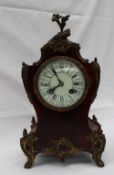 A 19th century tortoiseshell and gilt metal mantle clock the floral finial above a waisted body on