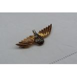 A 9ct gold jump wings badge with a central diamond set white metal parachute and two yellow metal