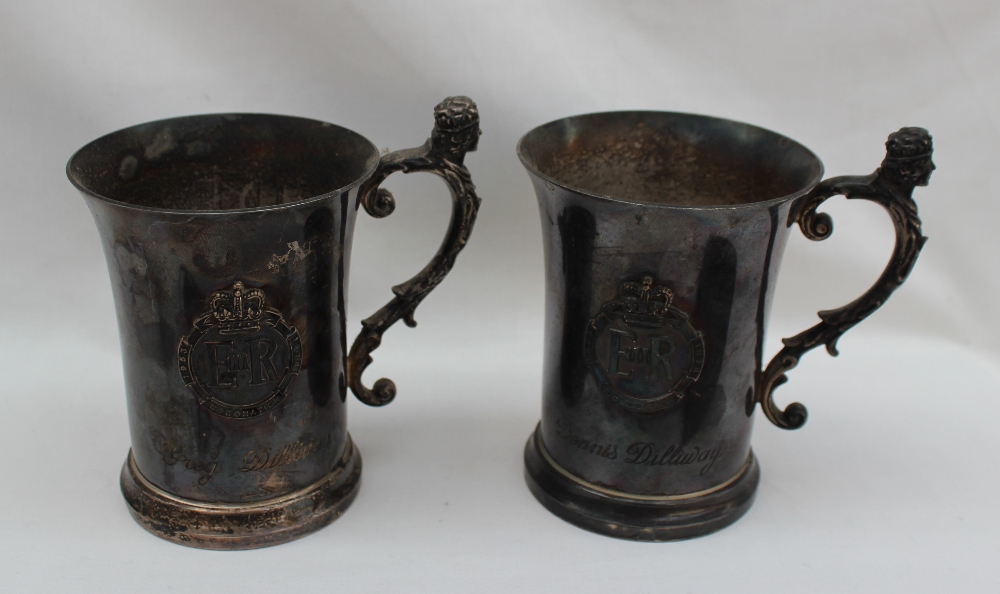 A pair of Elizabeth II silver tankards, the handle with a crowned head and leaves,