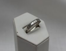 A diamond ring set with seventeen baguette cut diamonds to a white metal setting and shank marked