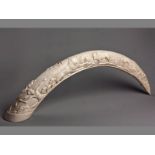 A LARGE EARLY 20TH CENTURY ELEPHANT TUSK engraved with an African hunting scene, on the reverse