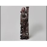 A 19TH CENTURY HARDWOOD FIGURE OF A SAGE holding a Peach of Immortality in his right hand and a