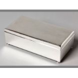 A .925 STERLING SILVER CIGARETTE BOX hinged top, interior cedar wood lined, standing on four ball-